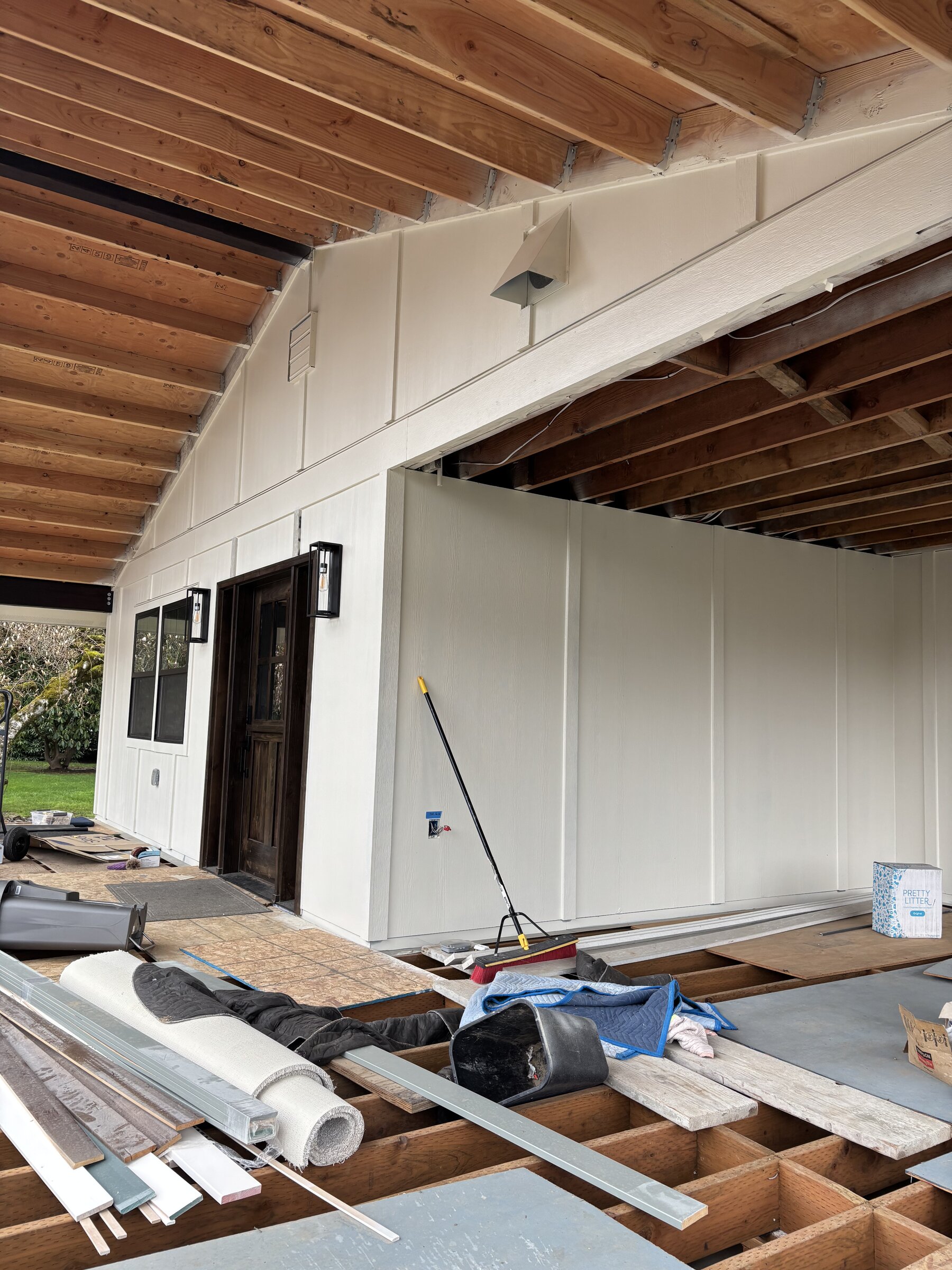 Covered outdoor living space with new siding during construction