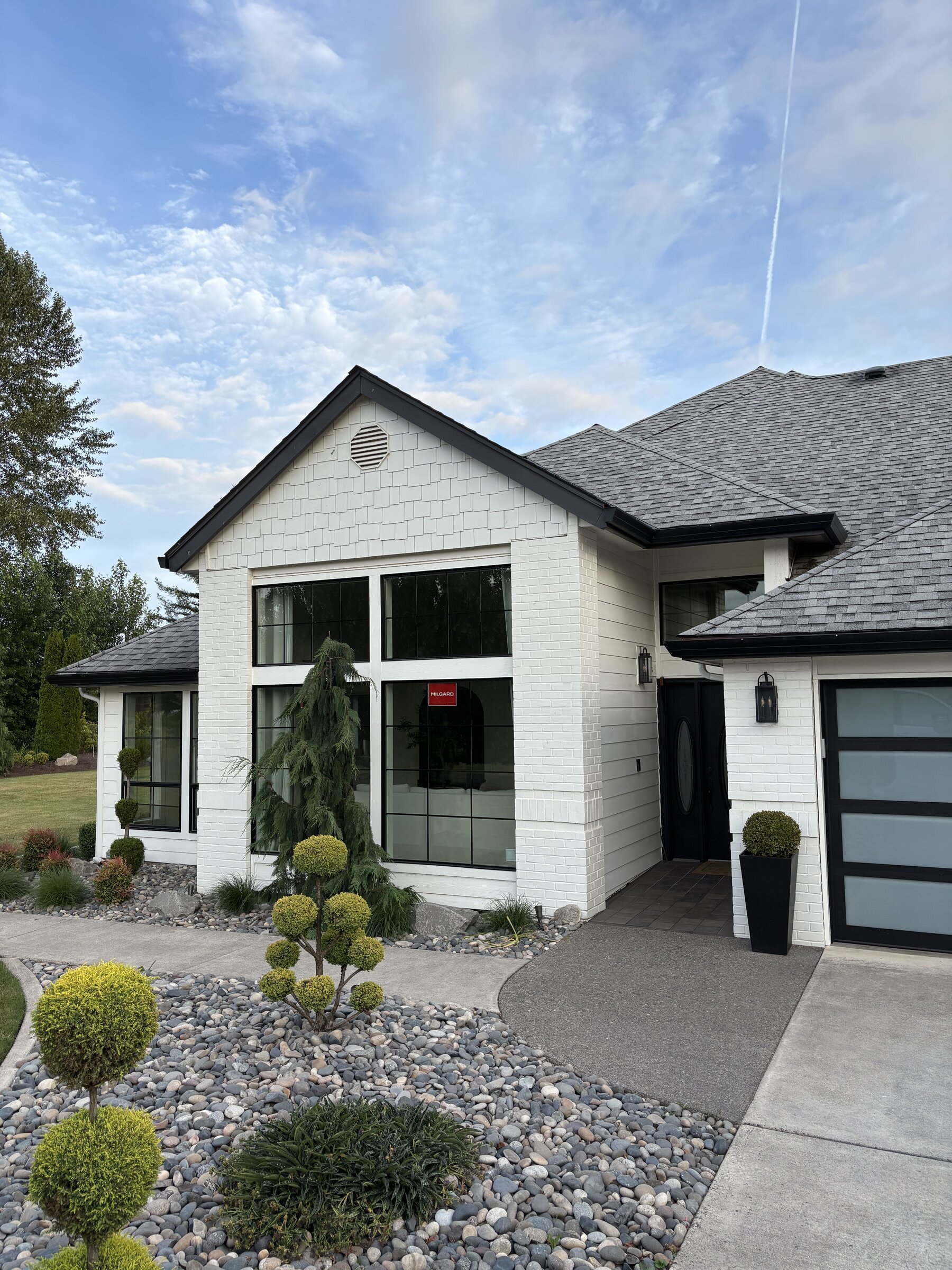 White exterior remodel with new roof, siding and black windows